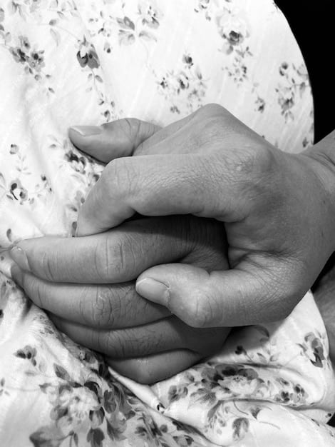A close-up of hands holding each other, representing comfort and support during times of grief. The image emphasizes empathy and connection.
