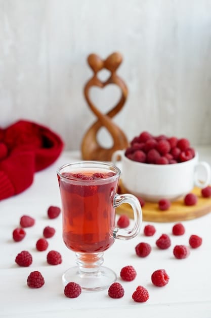 A calming image of a cup of herbal tea next to a bowl of berries, arranged on a wooden table with soft natural light.