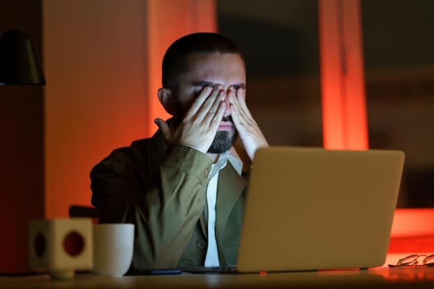 A close-up shot of a person looking stressed while working on a computer late at night, symbolizing the pressure and stress of modern work environments.