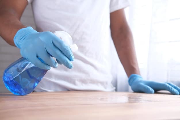 A person cleaning a kitchen countertop with a disinfectant spray and a cloth, emphasizing the importance of surface hygiene in the kitchen. The scene is well-lit and shows various cleaning supplies, creating a sense of diligence.