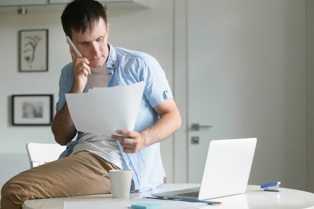 A person sitting at a desk looking stressed while reviewing medical bills and financial documents, with a laptop open in the background displaying the Social Security Administration website.