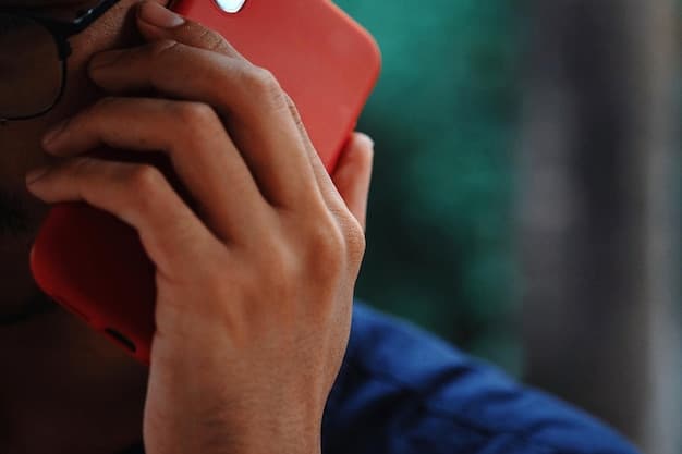 A close-up shot of a hand holding a phone, dialing a crisis hotline number against a blurred background of a person looking distressed.