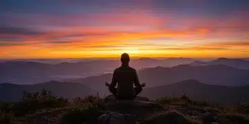 Person meditating on mountain, symbolizing emotional strength and peace.